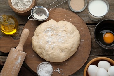 Photo of Fresh yeast dough and ingredients on wooden table, flat lay