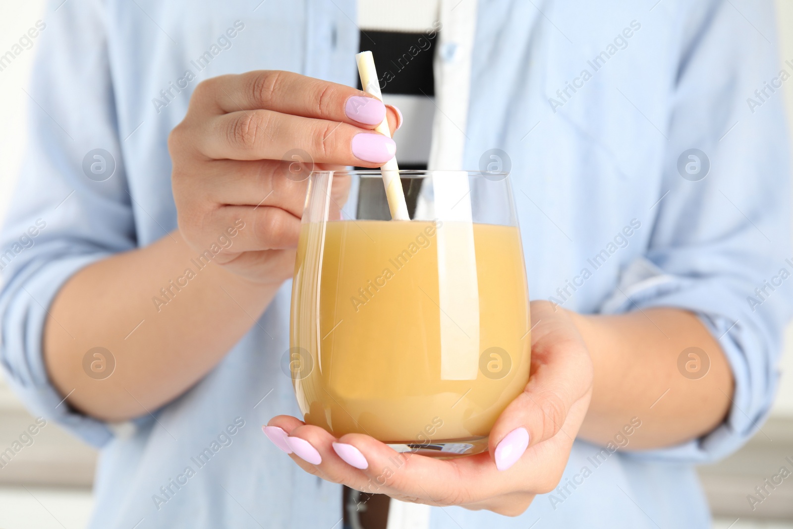 Photo of Woman holding tasty pear juice in glass, closeup