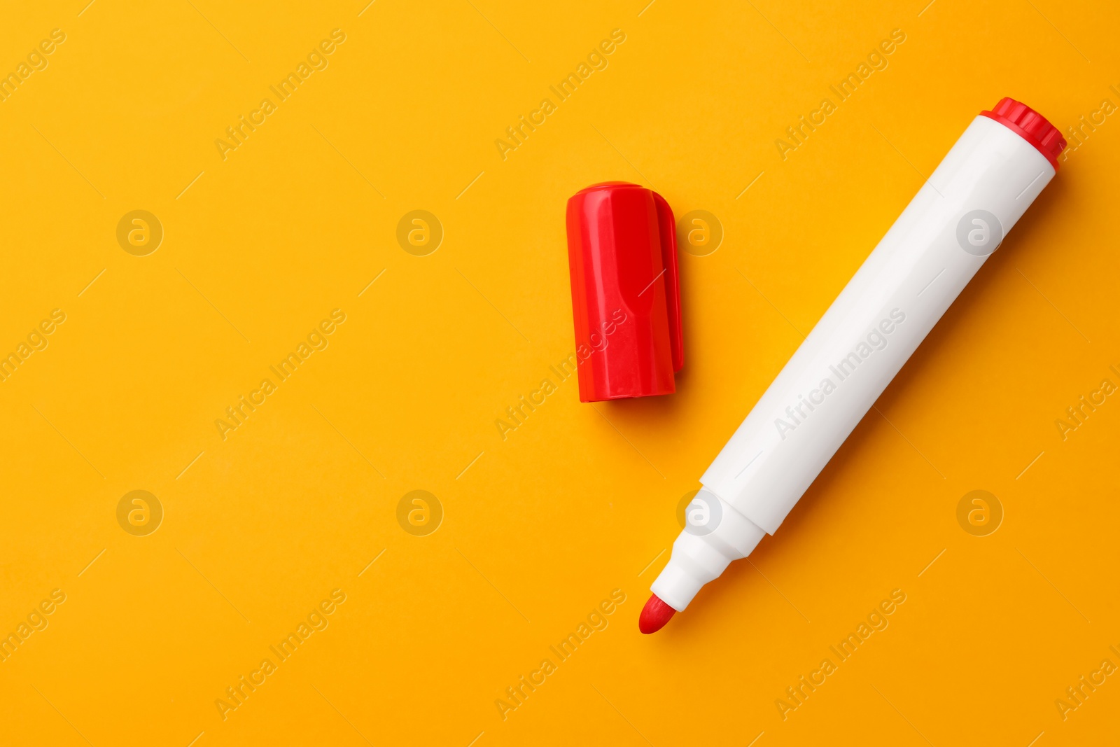 Photo of Bright red marker on orange background, flat lay. Space for text