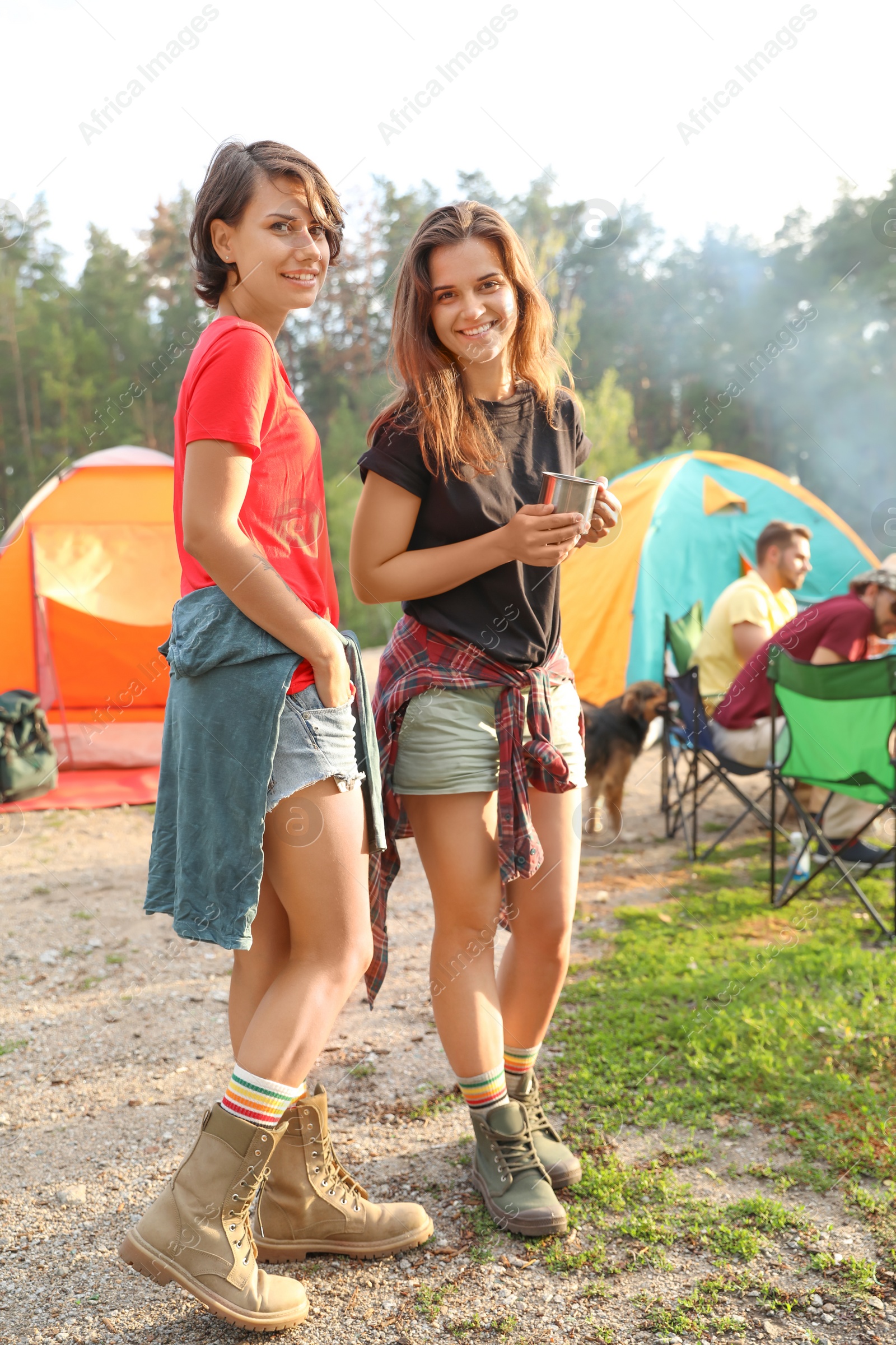 Photo of Young women near camping tents in wilderness