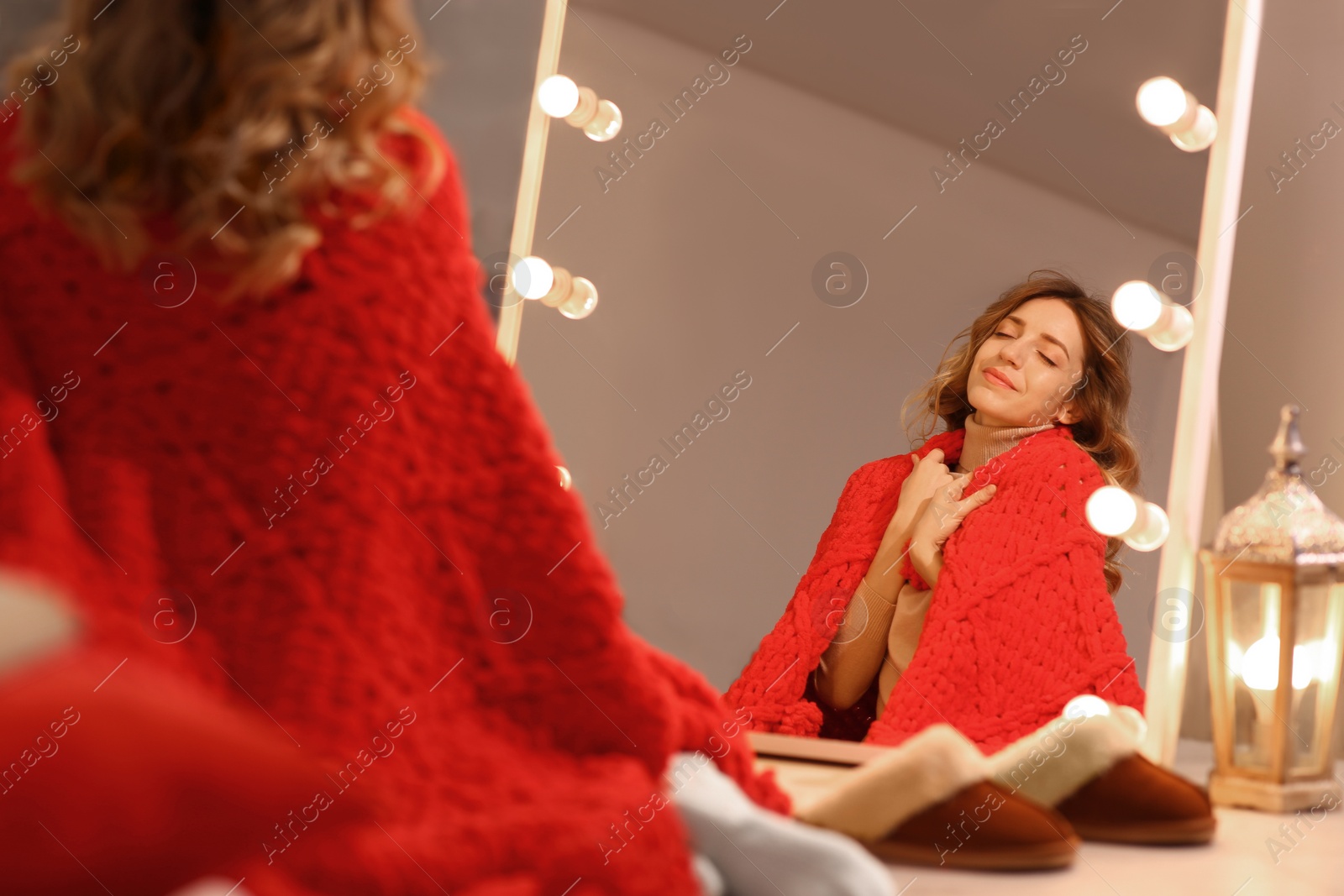 Photo of Beautiful young woman relaxing near mirror at home. Cozy atmosphere