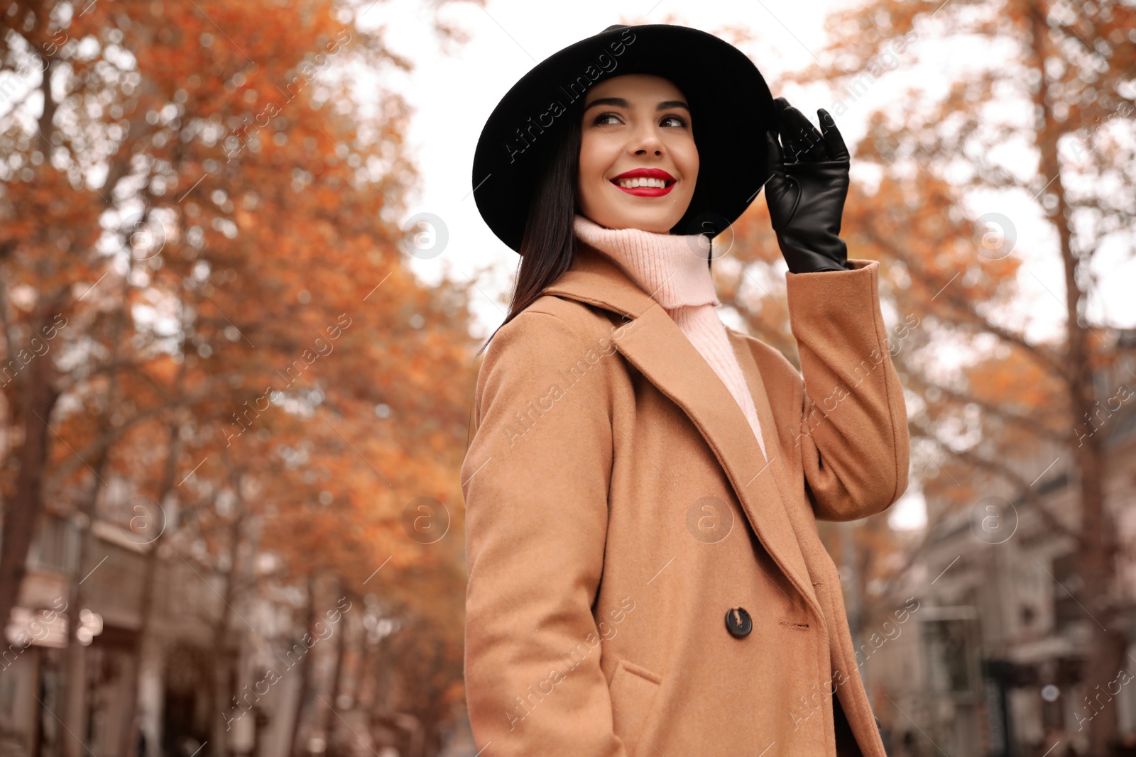 Photo of Young woman wearing stylish clothes on city street, space for text. Autumn look