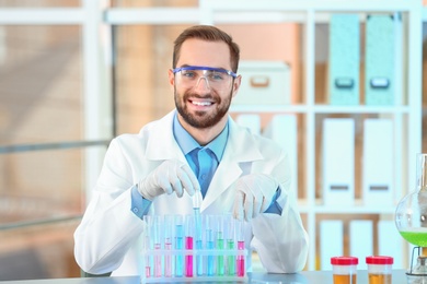 Photo of Young scientist working with test tubes in laboratory. Chemical analysis