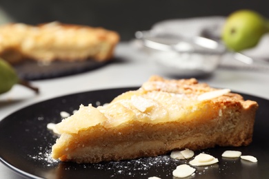 Photo of Piece of delicious sweet pear tart on table, closeup