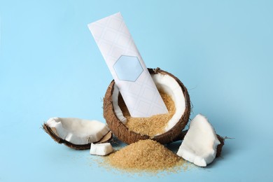 Photo of Scented sachet, coconut and brown sugar on light blue background