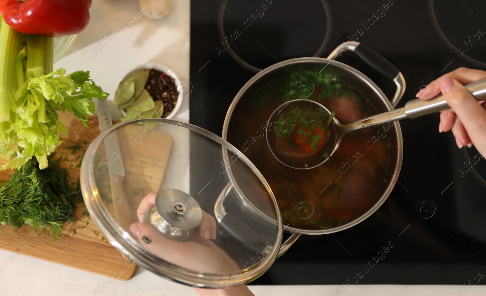 Photo of Woman making bouillon on stove, top view. Homemade recipe