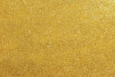 Photo of Beautiful golden shiny glitter as background, top view