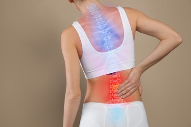 Image of Woman suffering from pain in back on beige background, closeup