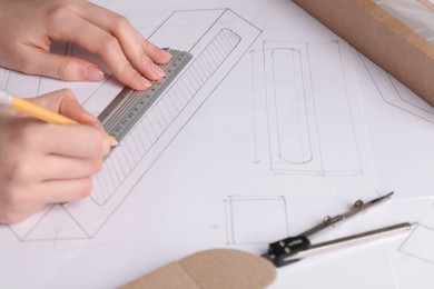 Photo of Woman creating packaging design on paper, closeup