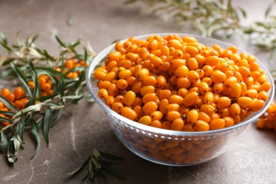 Photo of Ripe sea buckthorn berries on marble table, closeup