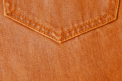 Texture of orange jeans as background, closeup