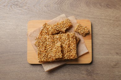 Photo of Delicious kozinaki pieces on wooden table, top view