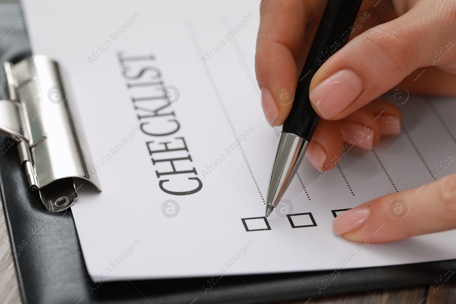 Photo of Woman filling Checklist at table, closeup view