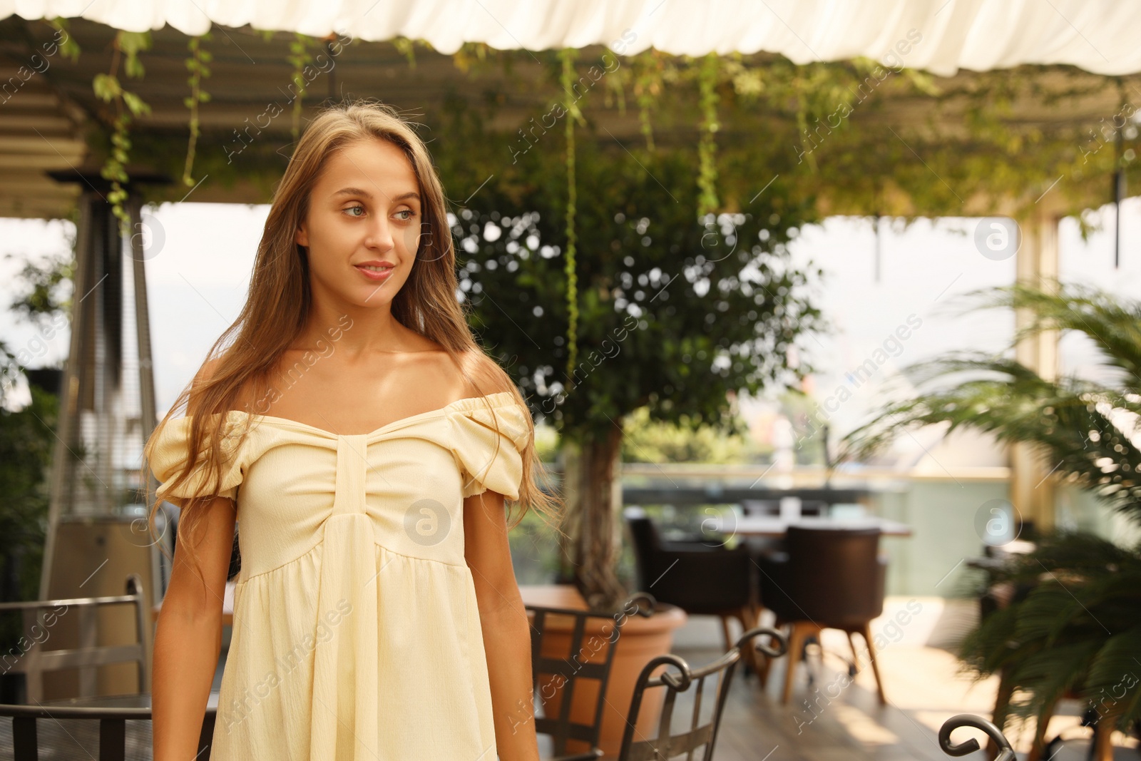 Photo of Beautiful young woman standing on indoor terrace,, space for text