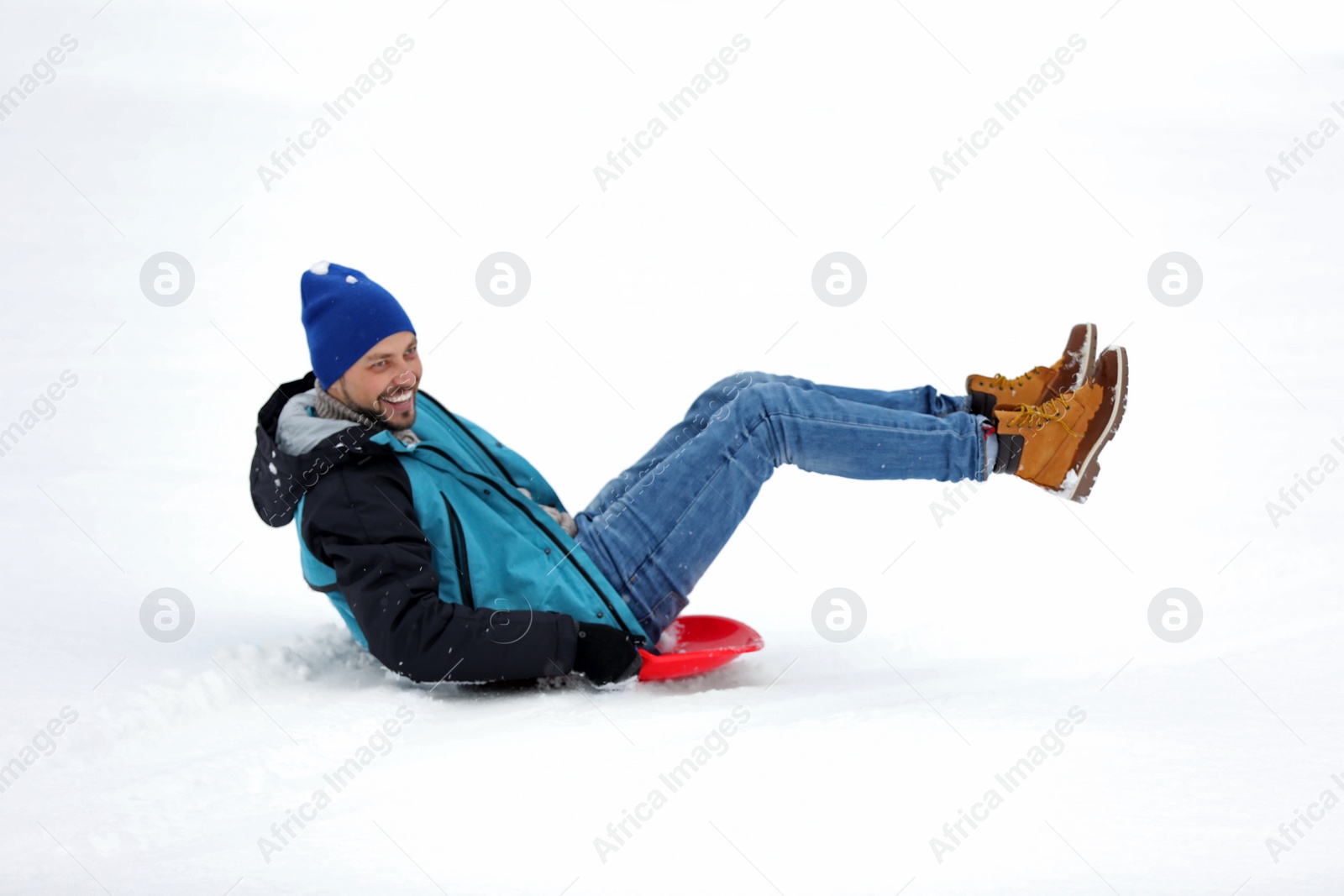 Photo of Man sliding on sled outdoors. Winter vacation