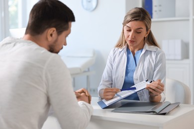 Photo of Professional doctor working with patient at white table in hospital