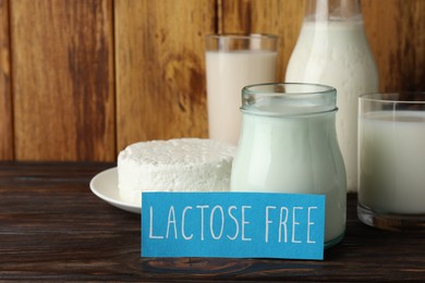 Photo of Card with phrase Lactose free and different fresh products on wooden table, space for text