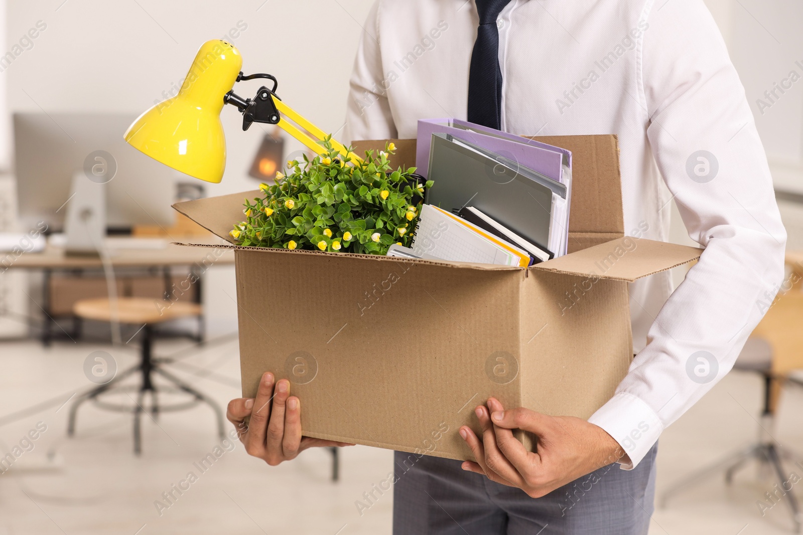 Photo of Unemployment problem. Man with box of personal belongings in office, closeup