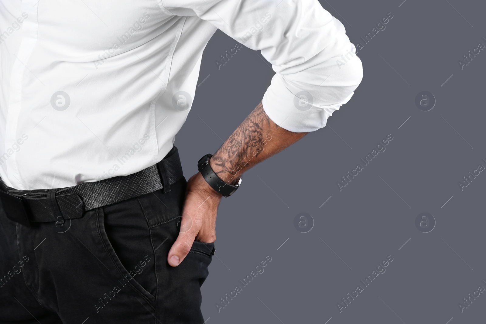 Photo of Closeup view of tattooed man on grey background. Space for text