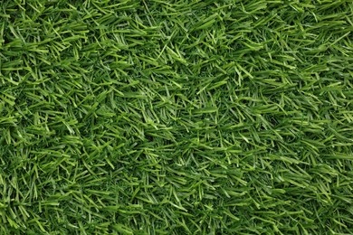 Green artificial grass as background, top view