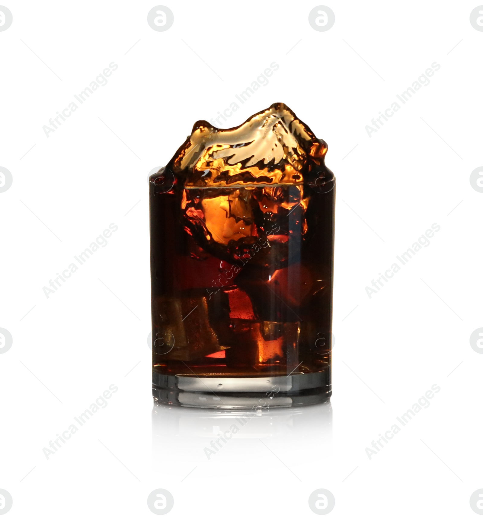 Photo of Whiskey splashing out of glass on beige background