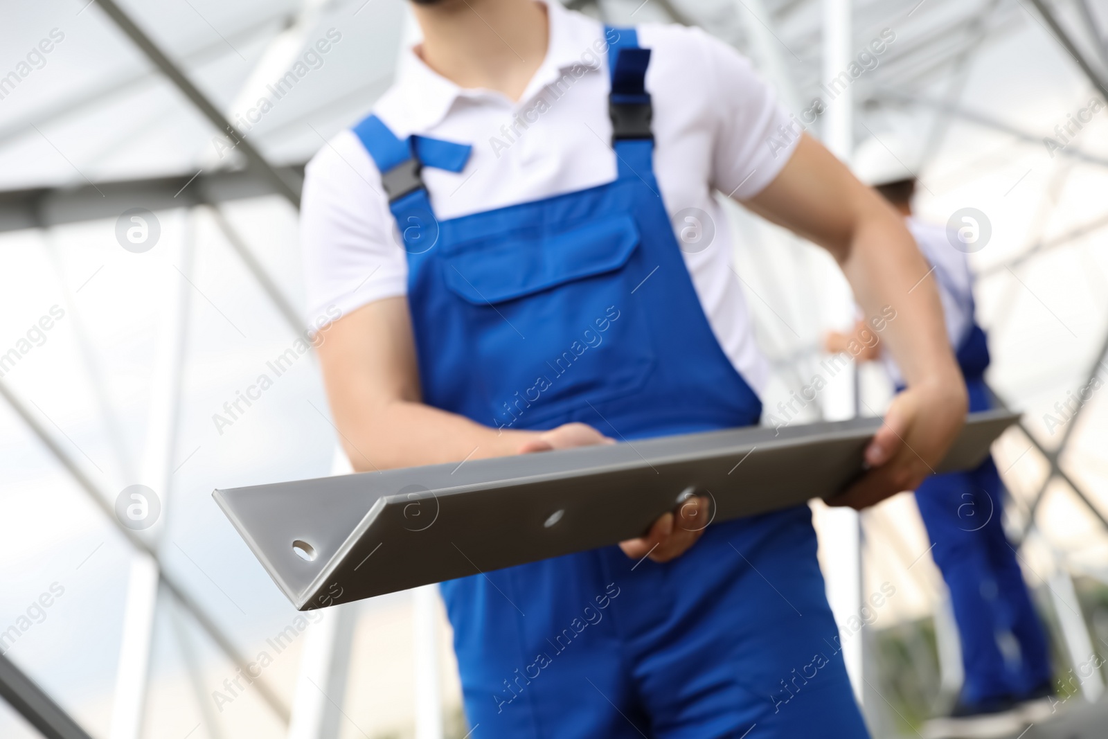 Photo of Worker with detail from high voltage tower construction on building site, closeup. Installation of electrical substation