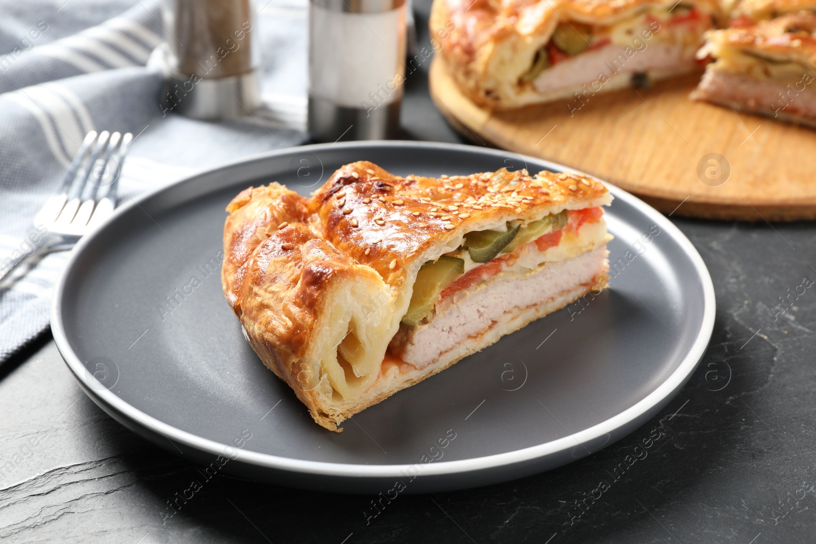 Photo of Piece of tasty homemade pie with filling on dark grey table