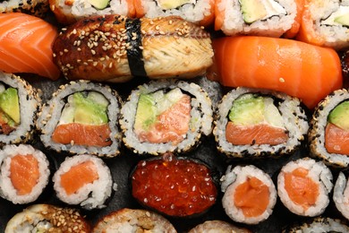 Photo of Different tasty sushi rolls as background, top view