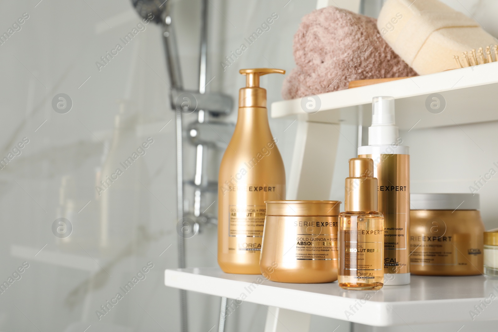 Photo of MYKOLAIV, UKRAINE - AUGUST 08, 2020: Set of L'Oreal hair care cosmetic products on white rack in bathroom. Space for text