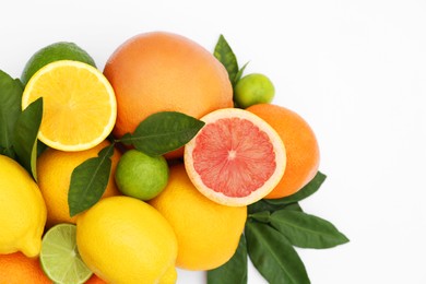 Different citrus fruits and leaves on white background, top view