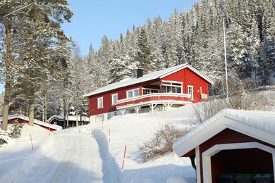 Photo of Beautiful view of cottages near snowy forest on winter day
