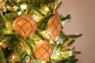 Christmas tree decorated with holiday baubles and fairy lights, closeup