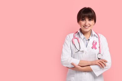 Mammologist with pink ribbon on color background, space for text. Breast cancer awareness