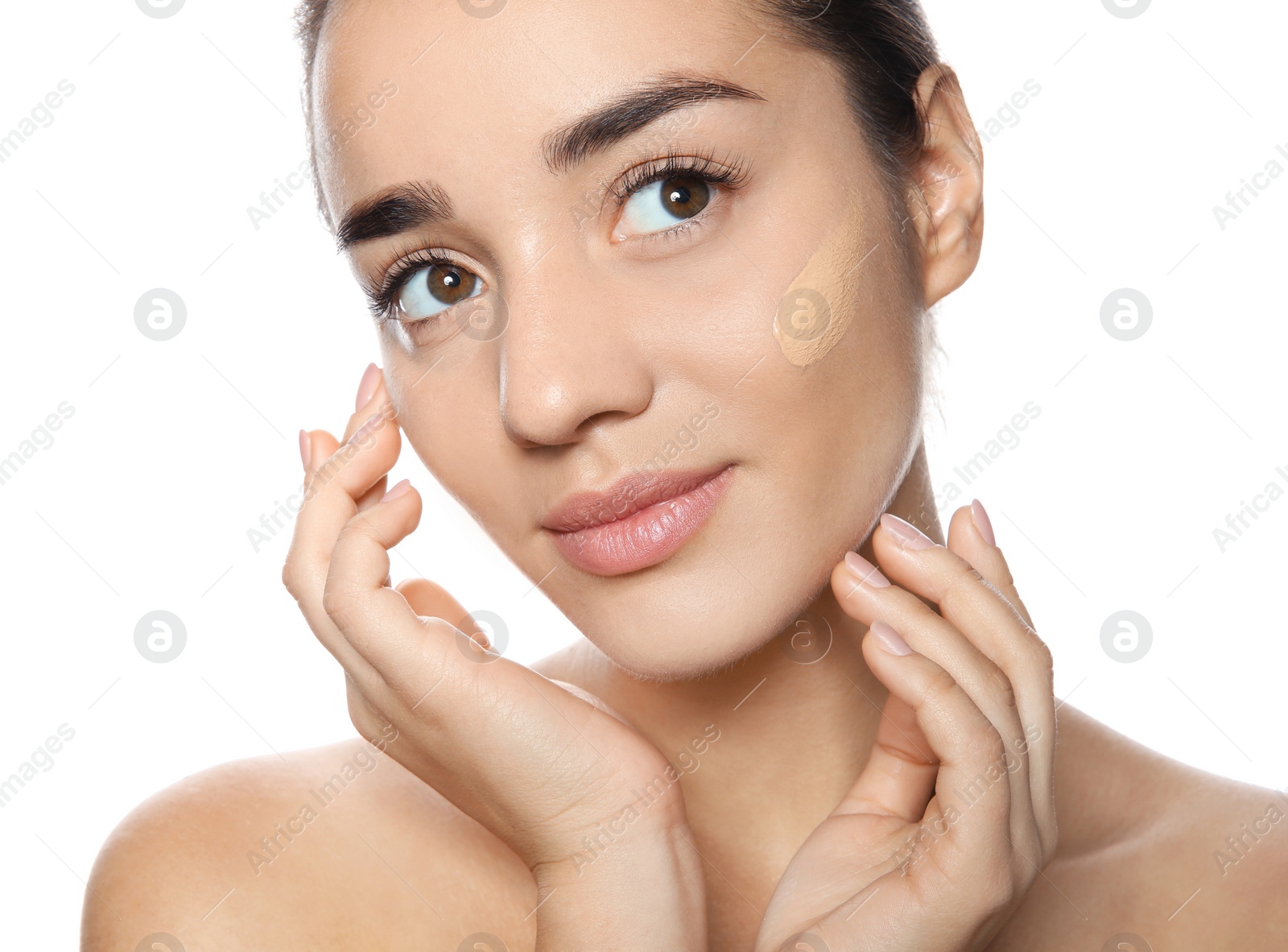 Photo of Portrait of young woman with liquid foundation on her face against white background