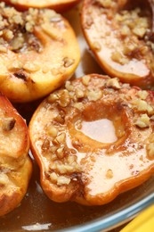 Photo of Tasty baked quinces with walnuts and honey in bowl, closeup