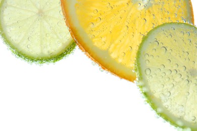 Photo of Slices of citrus fruits in sparkling water on white background, closeup