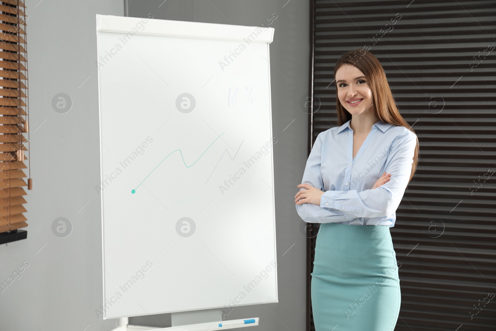 Photo of Professional business trainer near flip chart in office