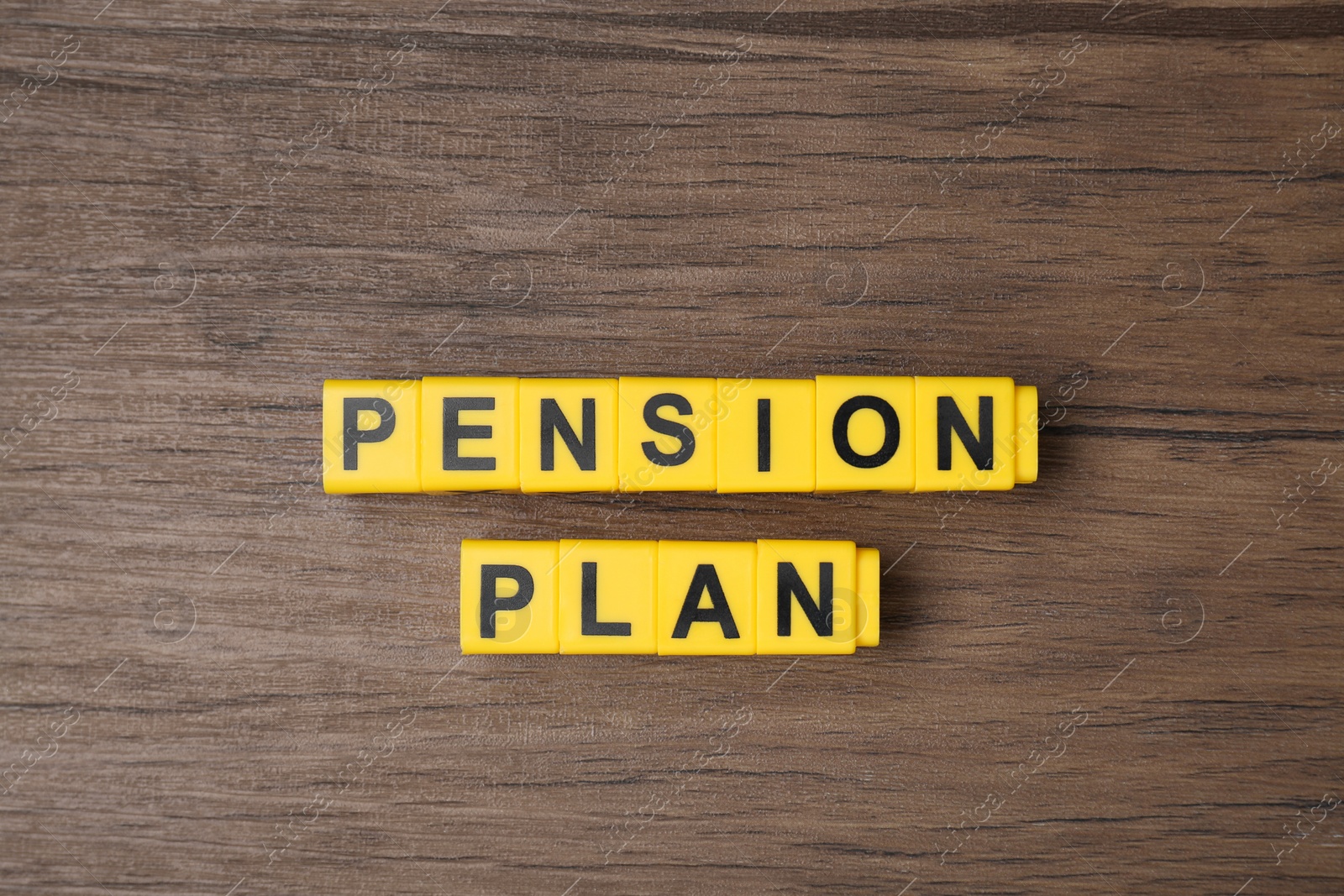Photo of Yellow cubes with phrase Pension Plan on wooden table, flat lay