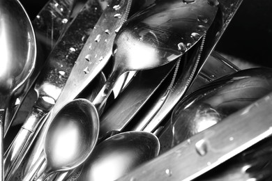 Photo of Washing silver spoons, forks and knives, closeup
