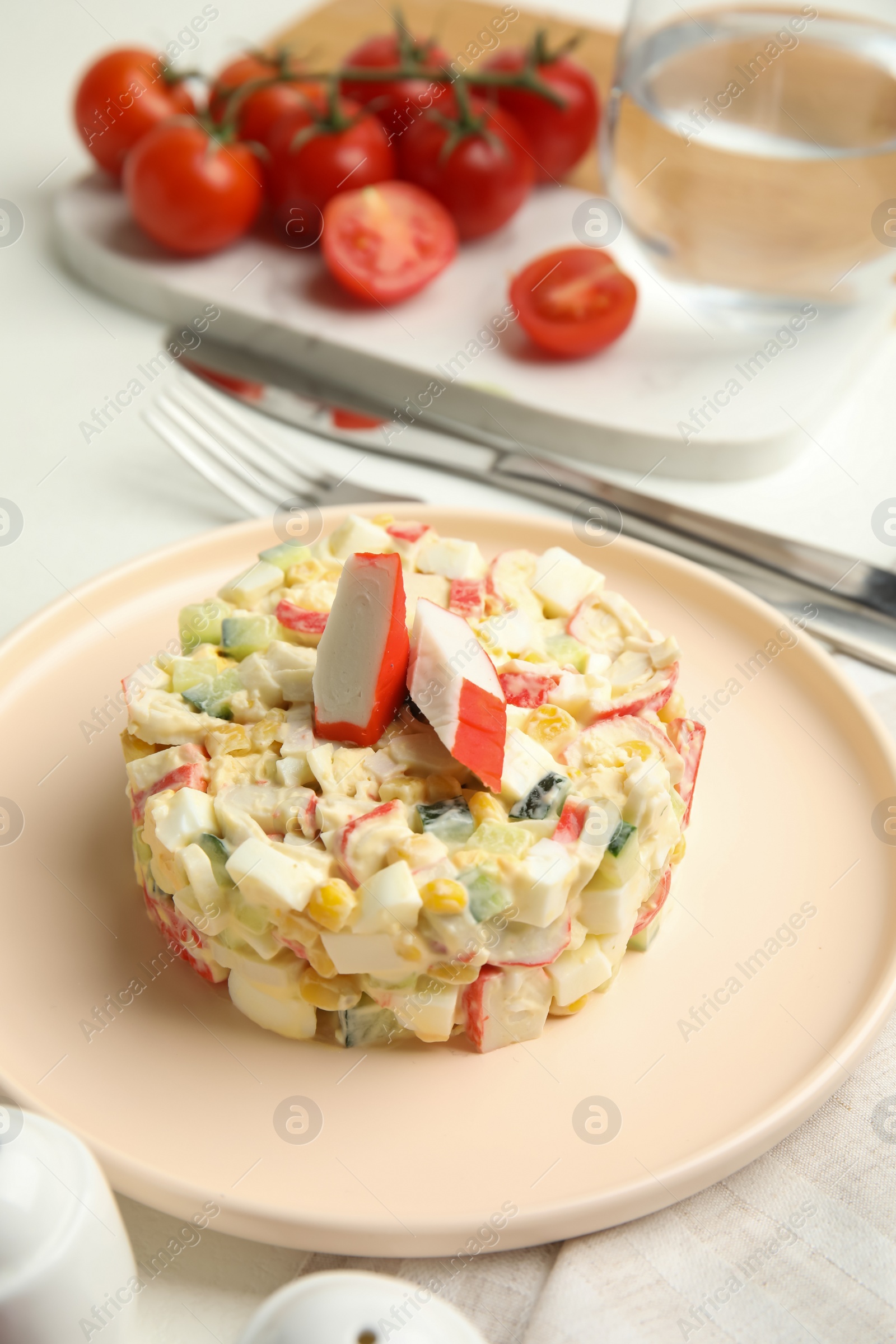 Photo of Delicious salad with crab sticks on table