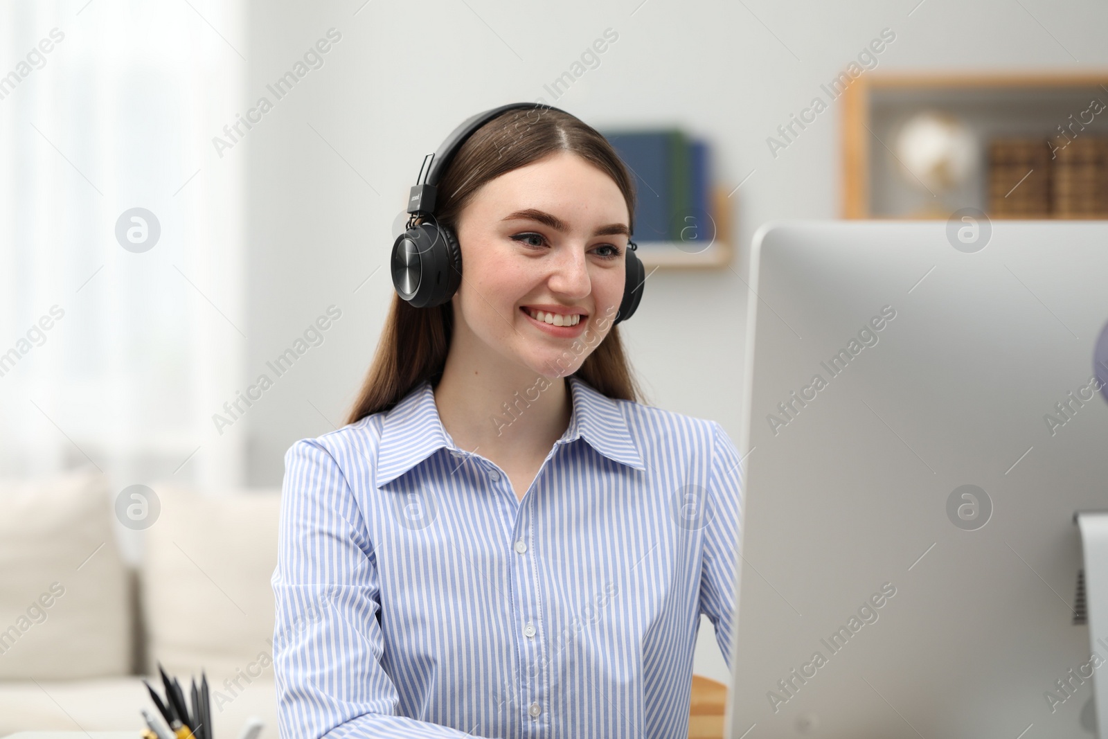 Photo of E-learning. Young woman studying with computer during online lesson indoors.