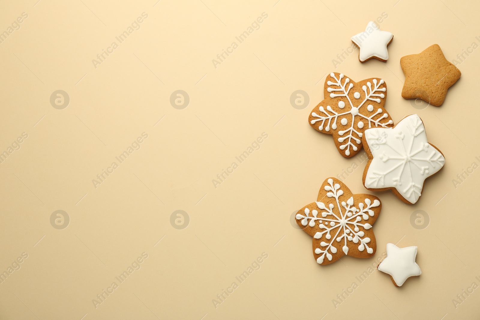 Photo of Tasty Christmas cookies with icing on beige background, flat lay. Space for text