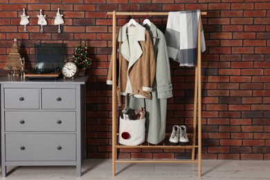 Photo of Modern hallway interior with Christmas decor and stylish furniture near red brick wall