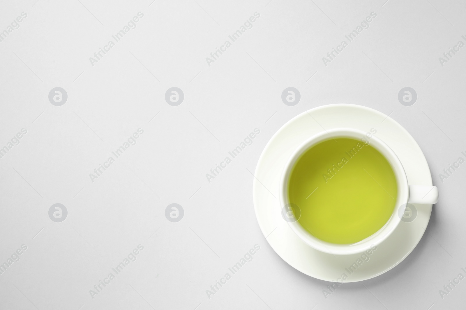 Photo of Cup of green tea on light background, top view. Space for text