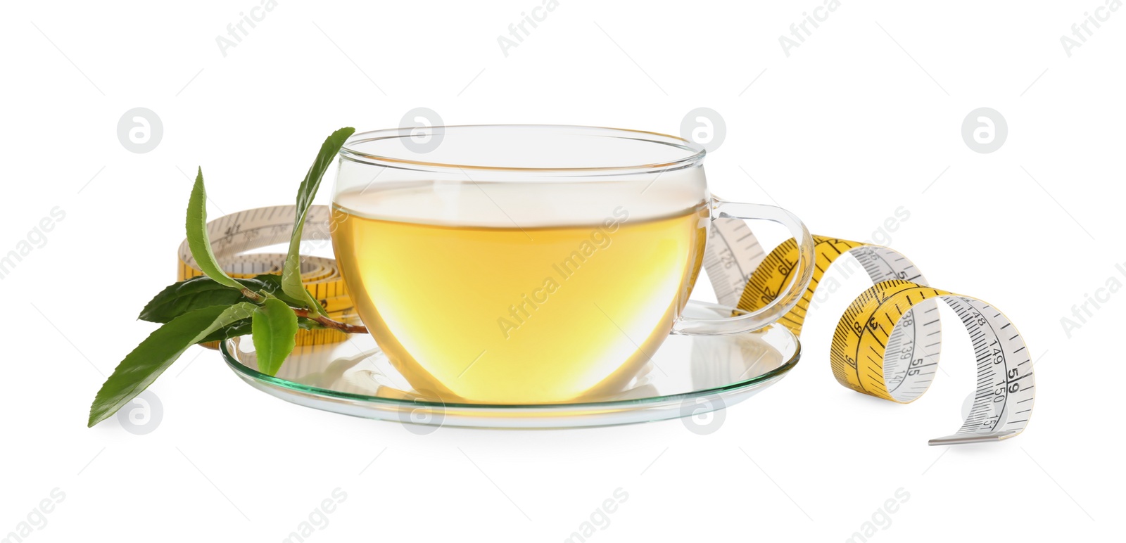 Photo of Glass cup of diet herbal tea, green leaves and measuring tape on white background