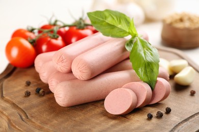 Photo of Fresh raw vegetarian sausages and vegetables on wooden board, closeup