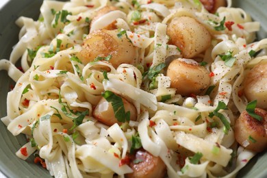 Delicious scallop pasta with spices in bowl, closeup