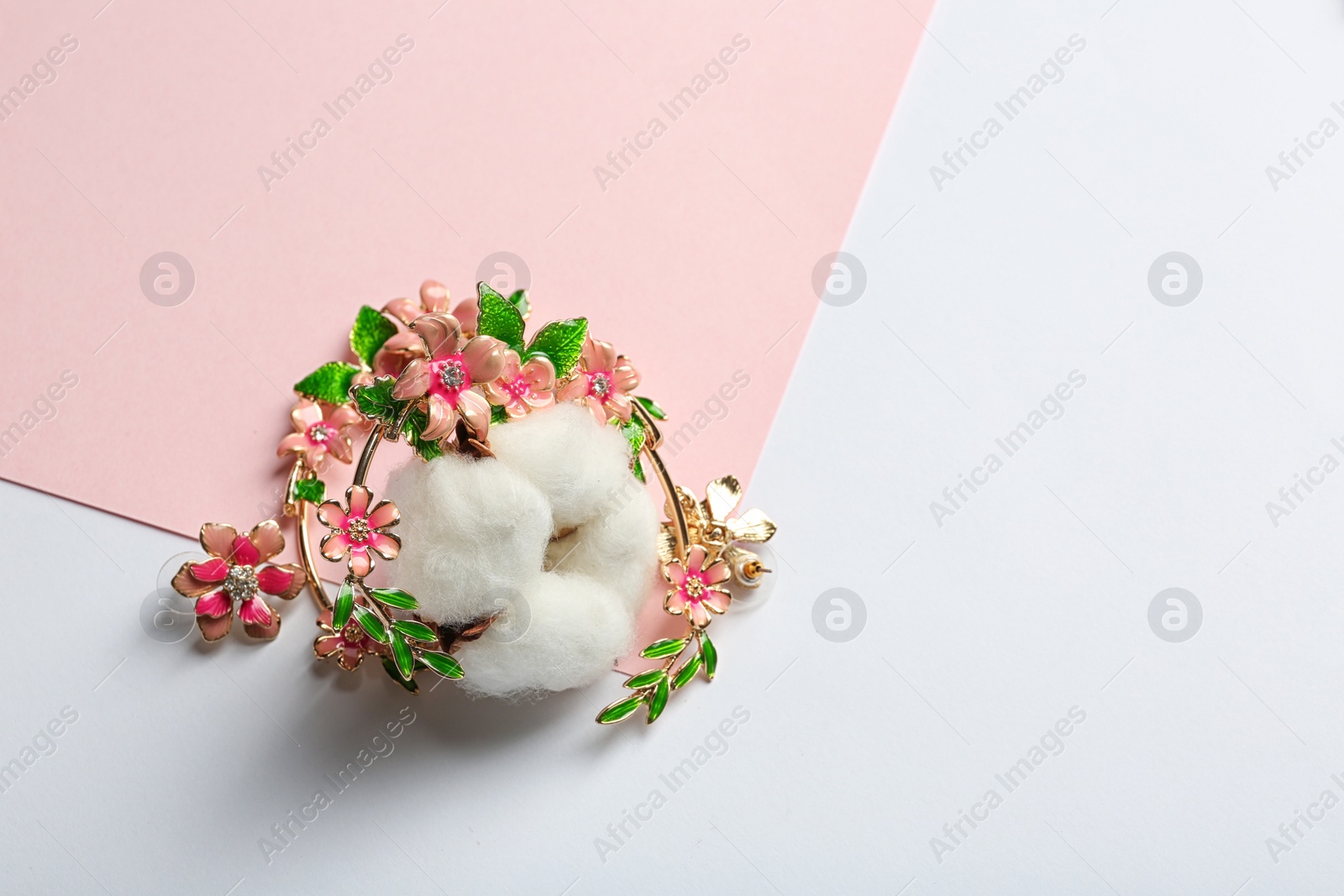 Photo of Stylish earrings and cotton flower on color background, space for text. Luxury jewelry