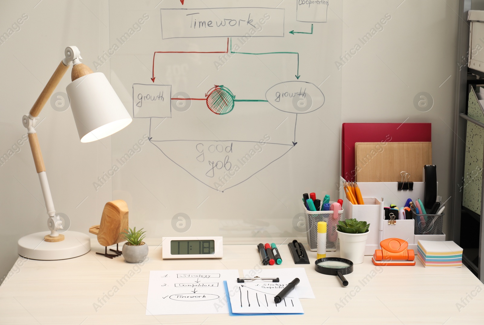 Photo of Business process planning and optimization. Workplace with lamp, notebook and other stationery on white wooden table