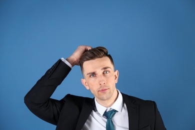 Portrait of young man with beautiful hair on color background